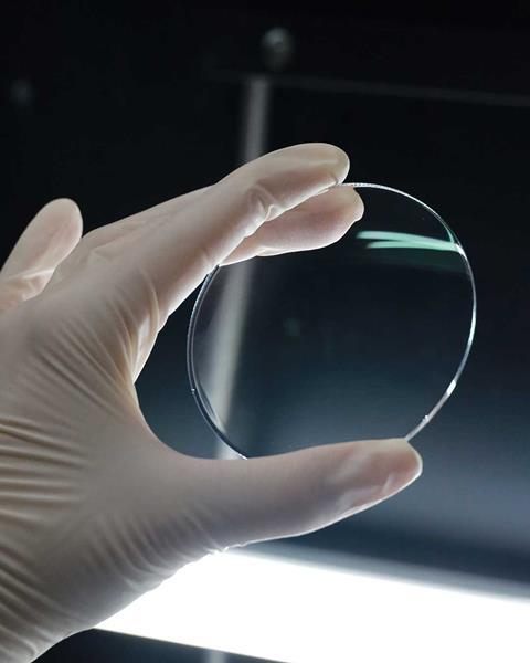 A hand holding an Optiswiss lens